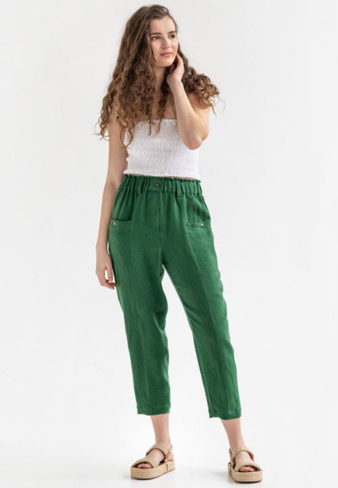model wearing the green linen pants paired with a white top and sandals