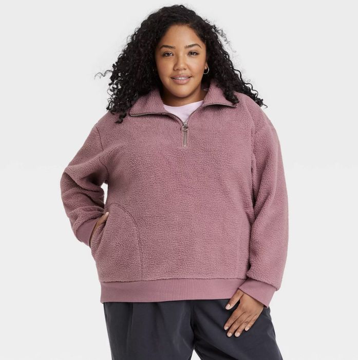 A model wearing the pink sherpa quarter-zip sweatshirt