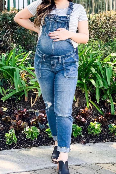 A reviewer wearing the maternity overalls