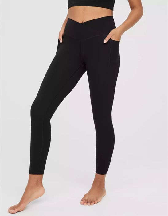 model showcasing the black crossover leggings with hands tucked into the pockets