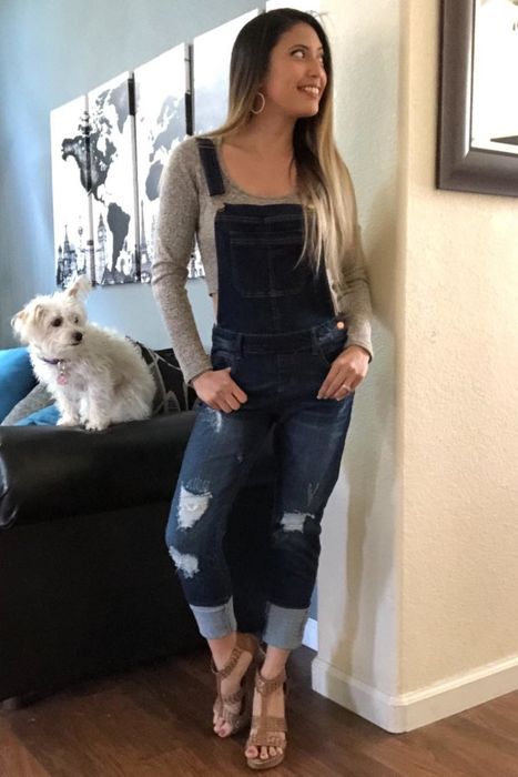 A reviewer modeling denim overalls