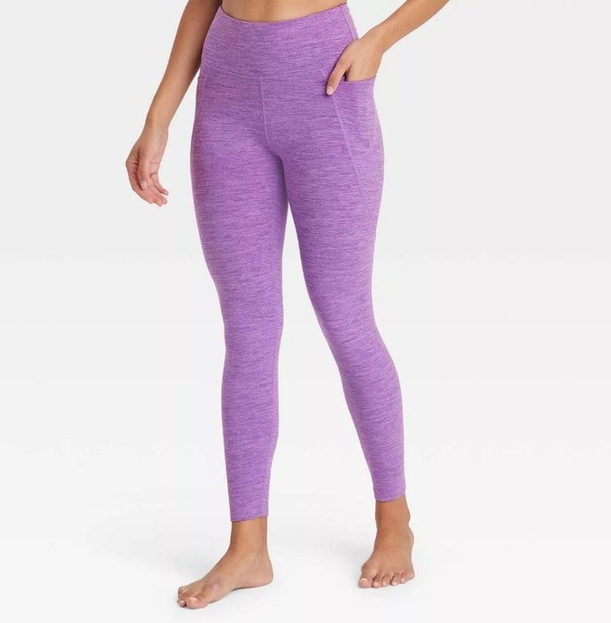 A model showcasing high-rise amethyst space-dye leggings featuring a convenient phone pocket