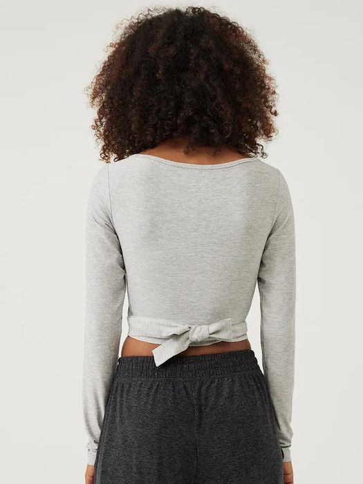 a model demonstrating the back of the sweater and its wrap-around design