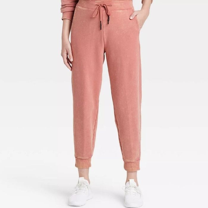A model wearing the same mid-rise French terry joggers in a vibrant rose red