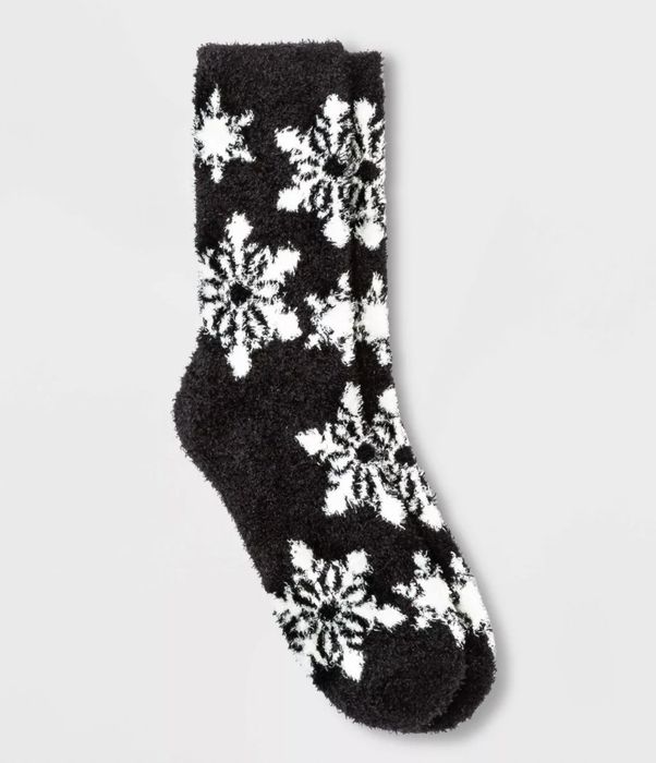 Pair of black crew socks featuring white snowflake designs