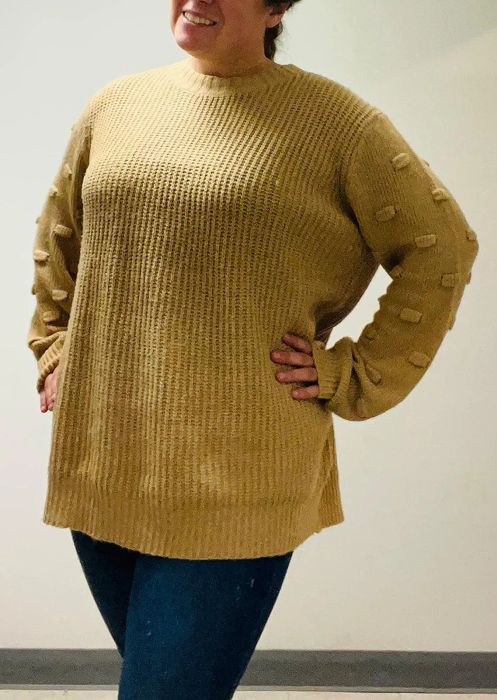 a reviewer wearing the sweater in a rich mustard yellow tone