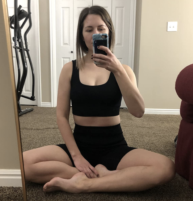 reviewer wearing the sleek black tank and matching shorts