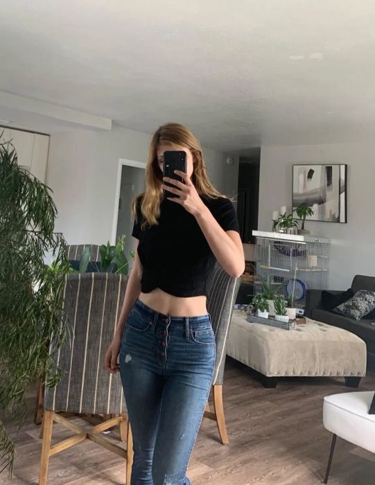 A mirror selfie of the reviewer wearing a black twist-front crop top.