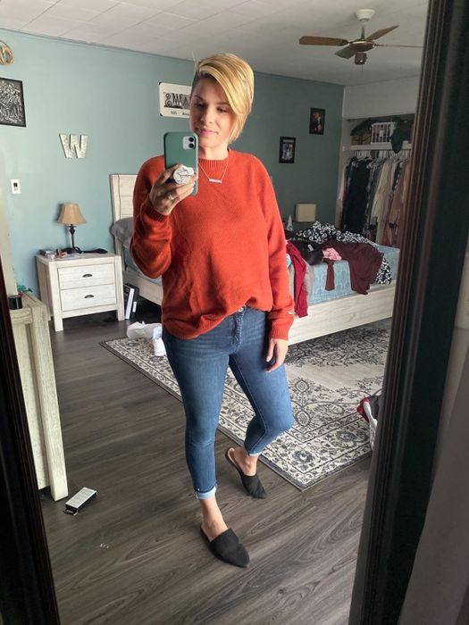 A reviewer wearing a red crewneck sweater