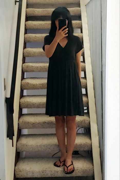 a reviewer modeling the black surplice dress