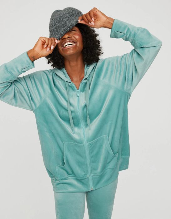 model wearing a teal zip-up velour hoodie