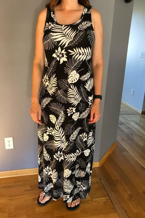 a reviewer modeling the sleeveless maxi dress adorned with a black and white palm print
