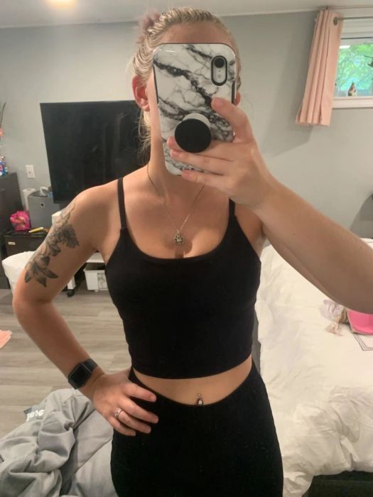 A reviewer snaps a mirror selfie wearing a black workout top.