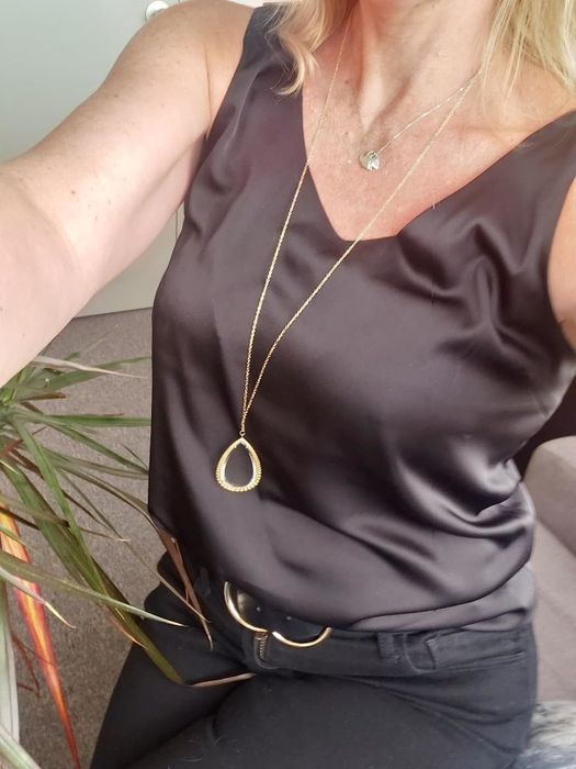 The reviewer is seen wearing a brown sleeveless V-neck camisole.