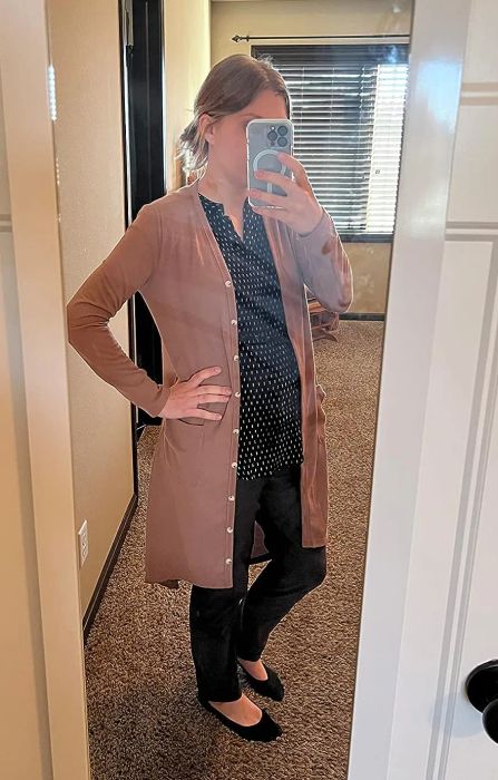 a reviewer showcasing the cardigan in a soft light brown tone
