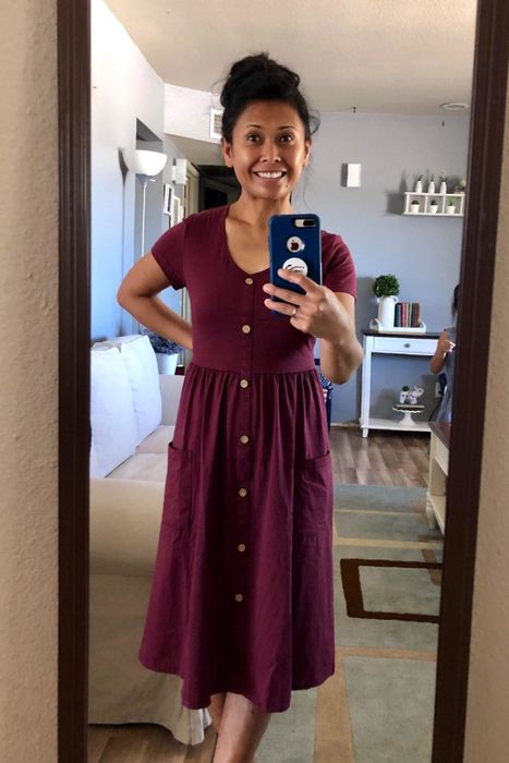 a reviewer sharing a mirror selfie in the short-sleeved midi dress featuring front buttons