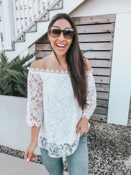 A reviewer wearing the lace off-the-shoulder top in white