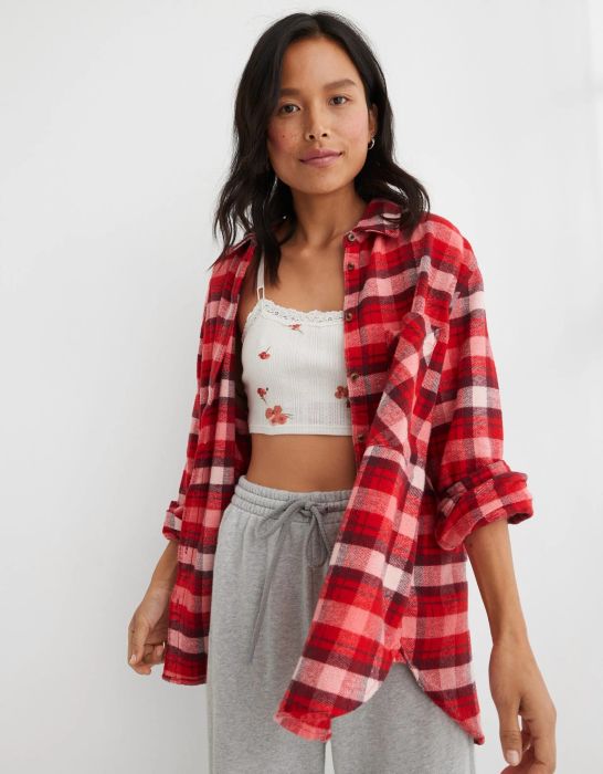 model in a red plaid flannel open button-up over a bralette