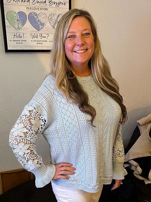a reviewer showcasing the sweater in a crisp white color