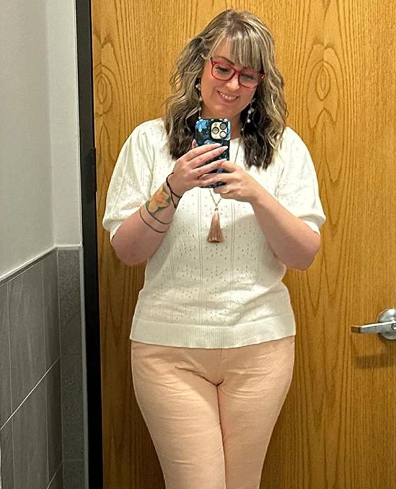 a reviewer showcasing the top in a soft off-white shade