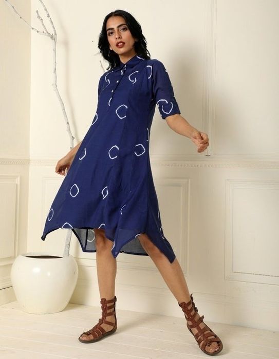 a model showcasing the blue collared dress featuring a handkerchief hem