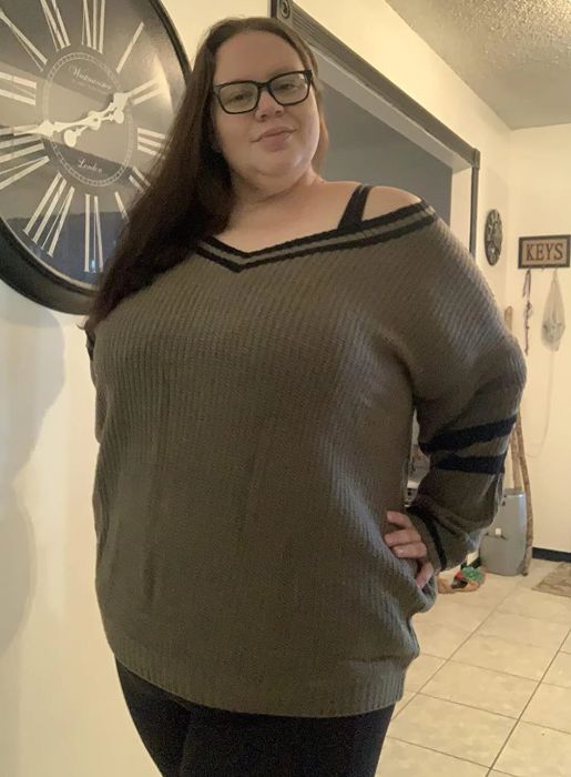 a reviewer modeling the sweater in gray with black accents