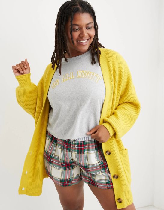 model wearing a bright yellow long knit cardigan with tortoise shell buttons