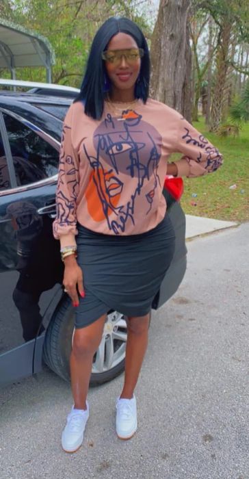 a reviewer modeling the sweater in a soft pink shade