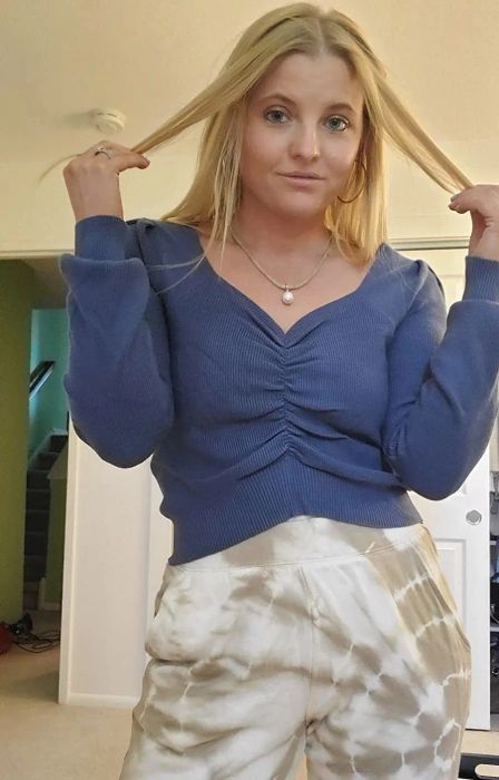 A reviewer wearing the sweater in a refreshing sea blue color