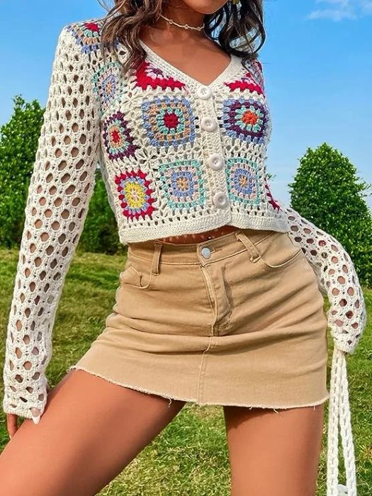 a model showcasing the buttoned-up sweater in white with multicolor accents
