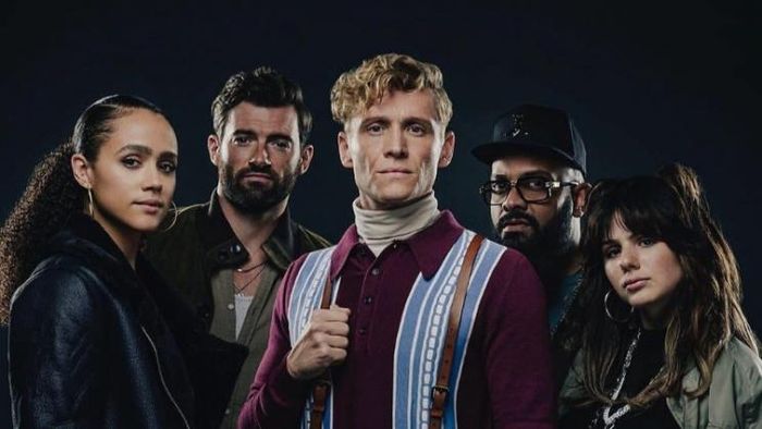 A reviewer standing in their classroom wearing the strawberry-patterned vest