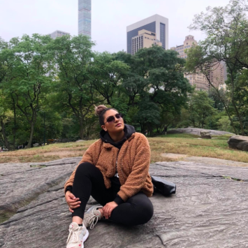 A reviewer photo featuring the light brown faux fur teddy coat styled with black leggings and sneakers