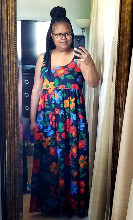 a reviewer sharing a mirror selfie in the navy dress featuring a vibrant multicolor floral print