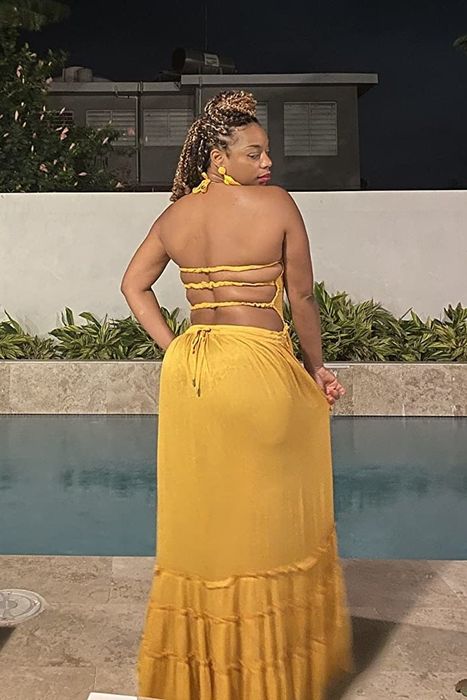 a reviewer showcasing the back view of the yellow open-back dress