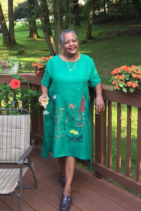A reviewer modeling the turquoise embroidered midi dress