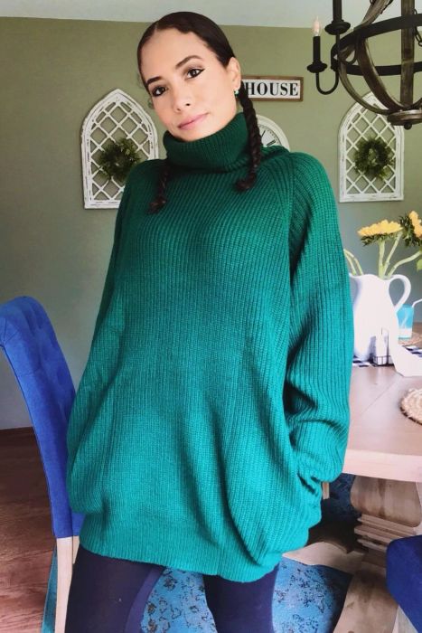 a reviewer wearing the sweater dress in dark green, paired with leggings