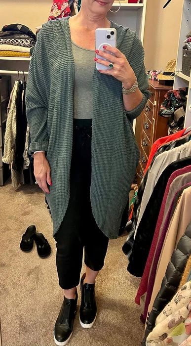 a reviewer wearing the cardigan in a rich dark blue tone