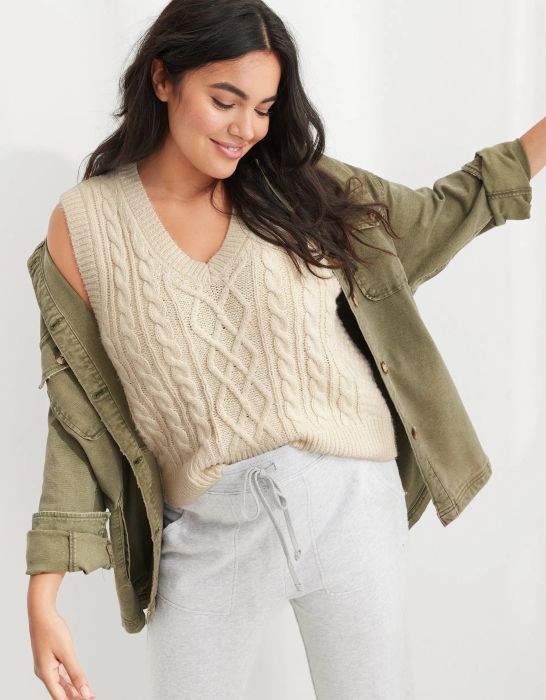 model wearing the beige cable-knit sweater vest