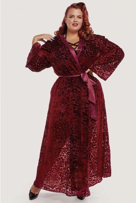 a plus-size model wearing the Playful Promises Aubergine Devore Gown, tied closed