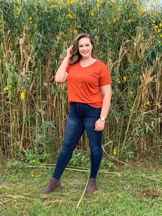 A reviewer wearing an orange V-neck T-shirt