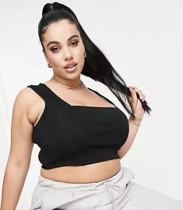 A model is seen wearing a square-neck black tank top.