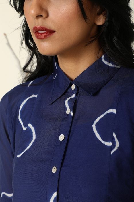 a detailed closeup of the pointed collar and front button fastenings