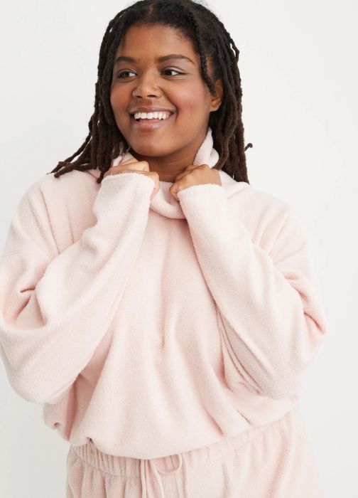 model in the light pink fleece turtleneck