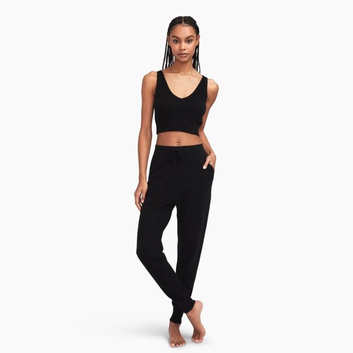 A model showcases a cropped black tank top.