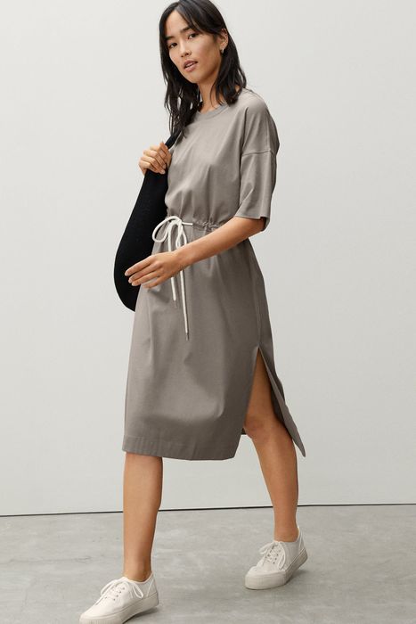 a model wearing the gray dress paired with white sneakers