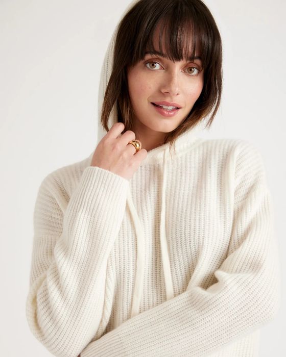 A model wears a white knit cashmere hoodie.