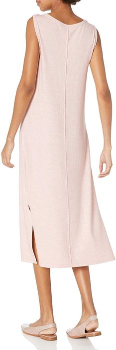 a model displaying the back view of the blush pink midi dress, featuring a center seam running down the back