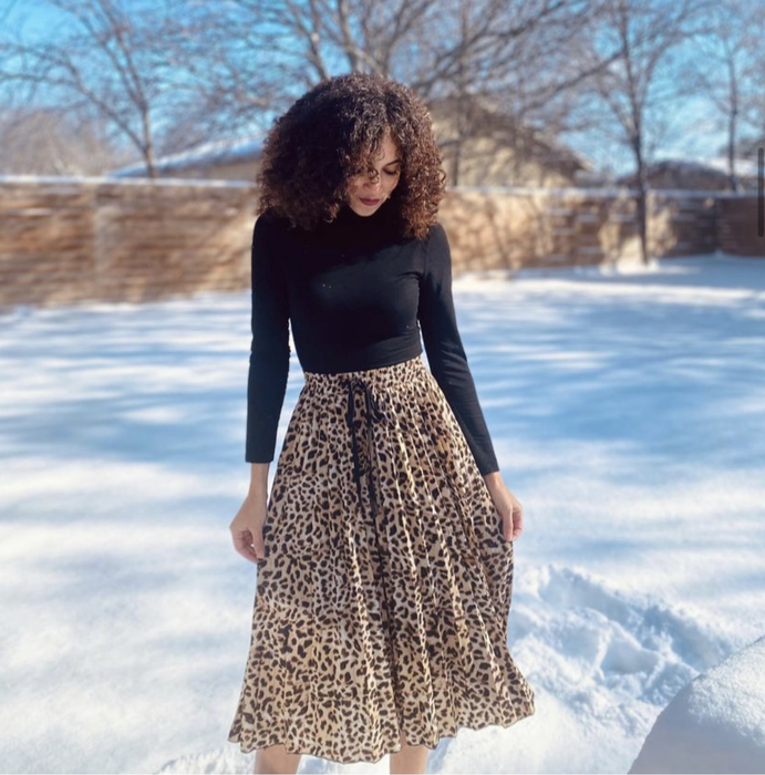 a reviewer photo showing off the black mock turtleneck bodysuit paired with a leopard print midi skirt