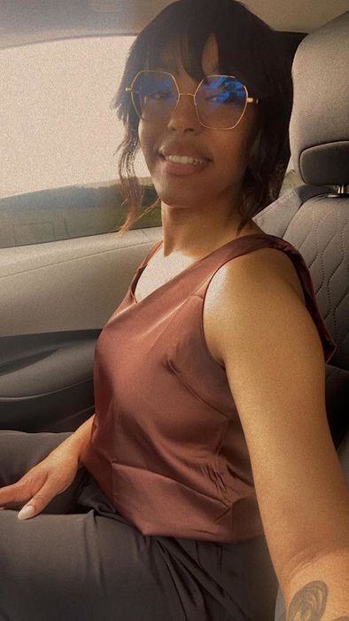 A reviewer wearing the same cami in a deep brown shade