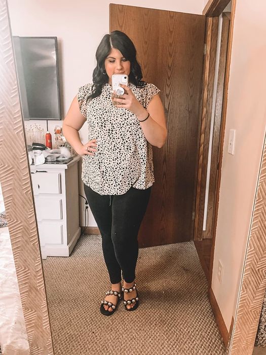 Reviewer wearing a white tunic top with black spots